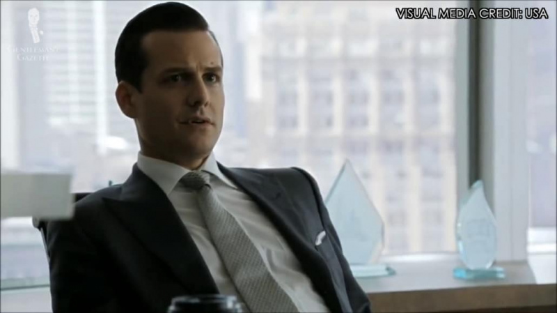 Harvey Specter dans un costume à boutonnage simple avec des revers pointus.