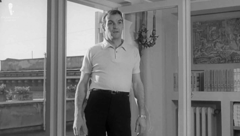 Stanley Baker em Eva (1962) vestindo uma camisa polo