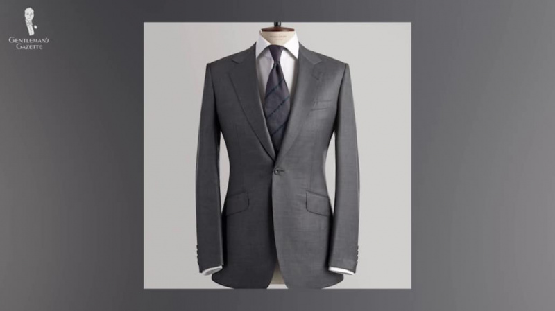 Sivo odijelo s kosim džepovima na preklop