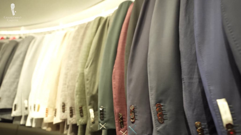 Колекција обешених одела у различитим бојама.