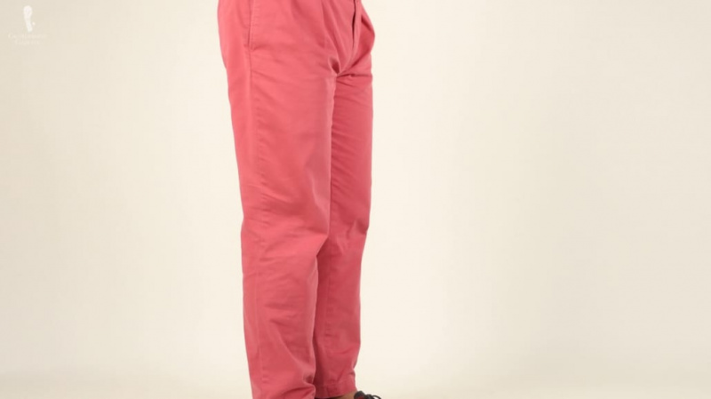 Červené chino kalhoty lze také kombinovat s šedým svetrem.