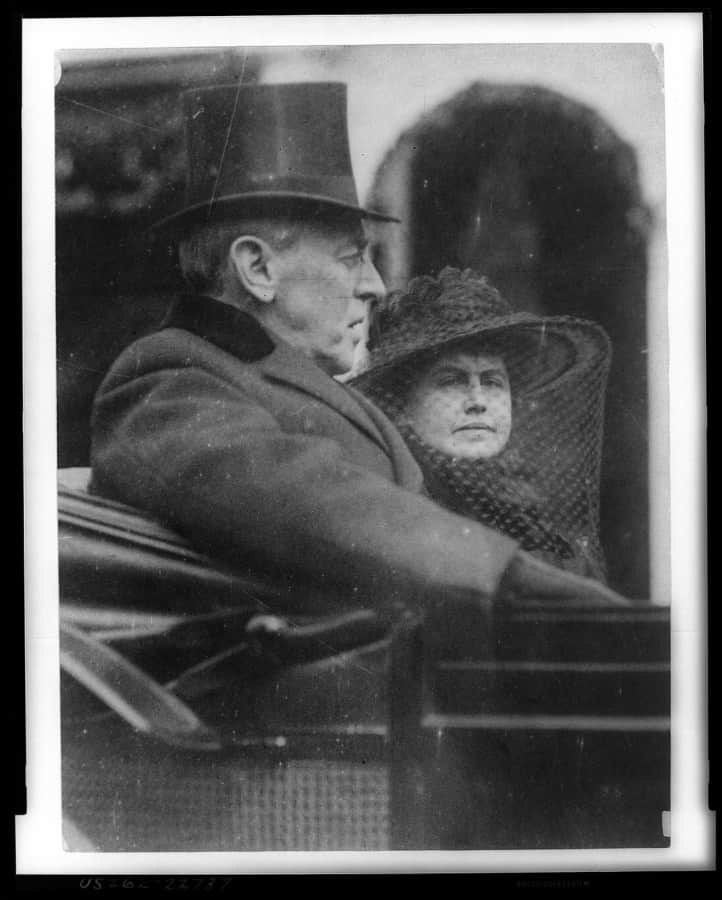 Woodrow Wilson a manželka jedoucí na zadním sedadle kočáru na druhou inauguraci s cylindrem a sametovým límcem 5. března 1917