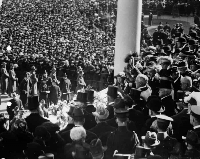 Prezident Harding mává davu z inauguračního stánku na východním sloupoví Kapitolu USA, 4. března 1921