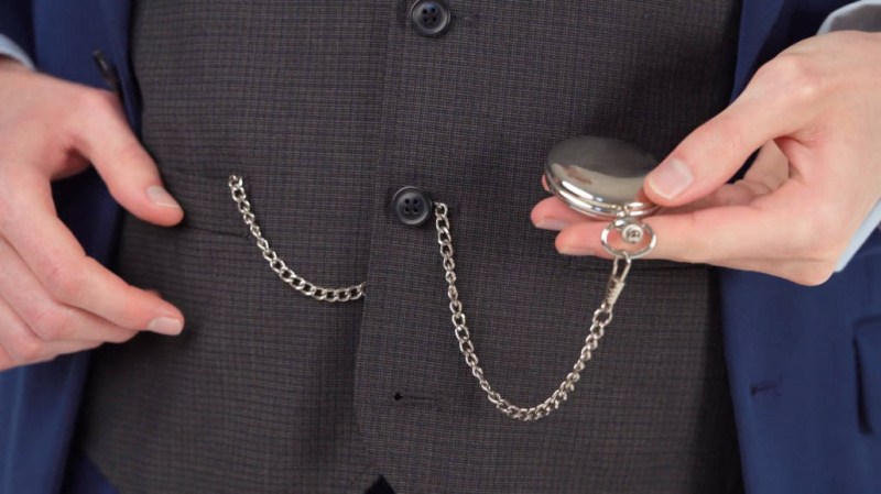 Preston portant une montre de poche avec une seule chaîne, enfilée à travers le gilet pour simuler une chaîne Double Albert