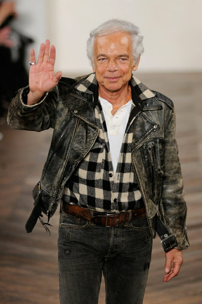 Ralph Lauren fait signe sur le podium dans une veste en cuir et un jean