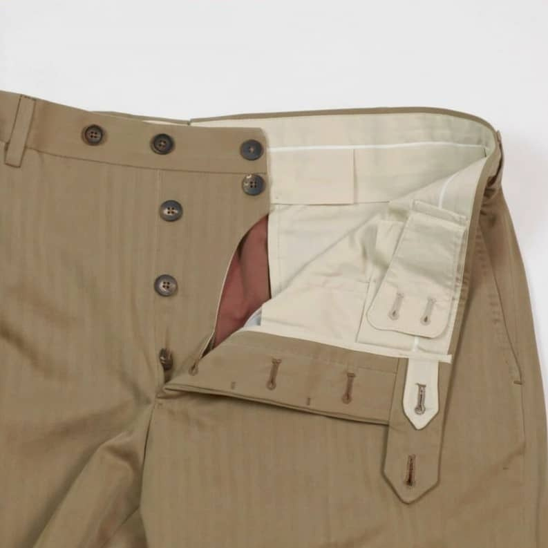Le French Bearer est une patte de pantalon pour soutenir la braguette lors du boutonnage.