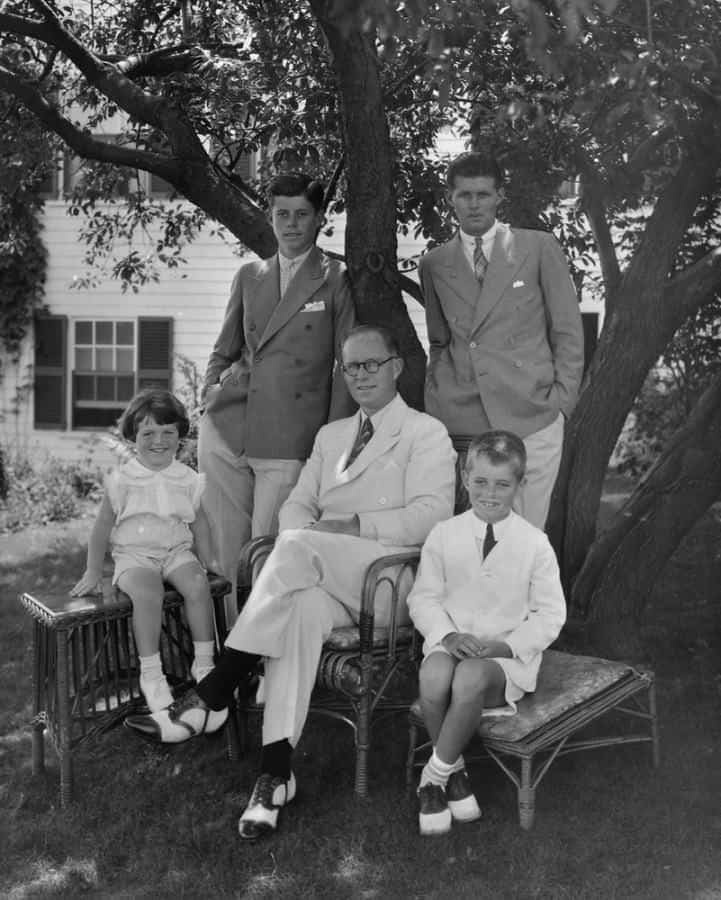 Jeune JFK avec une combinaison à double boutonnage et une épingle de col avec le père Joe et ses frères et sœurs