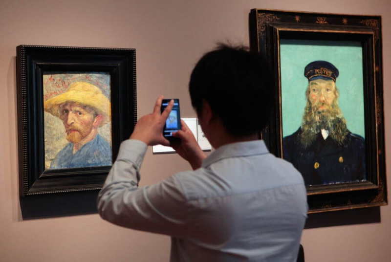 Een bezoeker van het Detroit Institute of Arts-museum gebruikt zijn mobiele telefoon om foto
