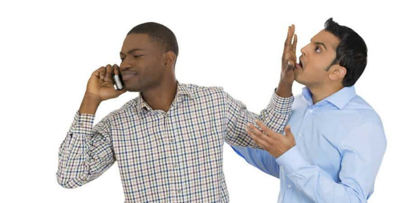 човек обара другог момка док прича преко телефона