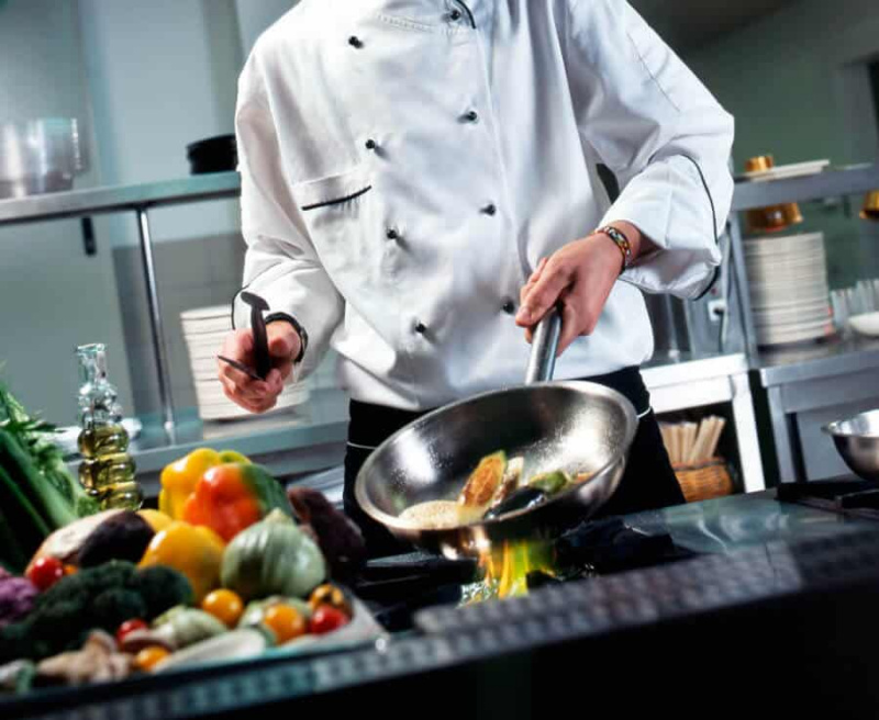 Un chef utilisant ses ustensiles de cuisine dans la cuisine