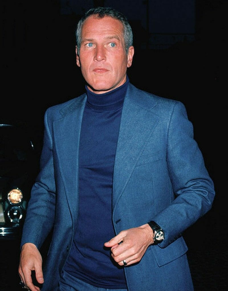 Paul Newman dans un col roulé bleu et un costume.
