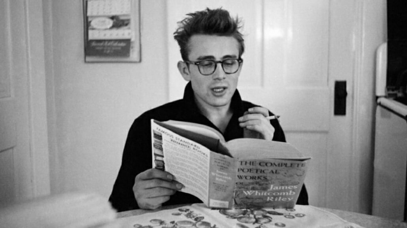 Дин носи наочаре од оклопа корњачевине да чита књигу поезије.