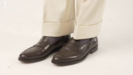 Тамнобраон мокасинке које се носе са сивим чарапама и прљаво белим панталонама