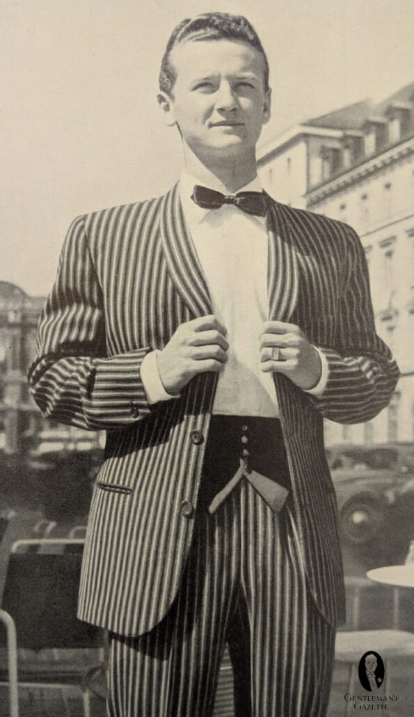 Francouzský střih 60. let 20. století na pruhovaném smokingu s šálovým límcem a prošívanou vestou, kterou lze zapnout uprostřed