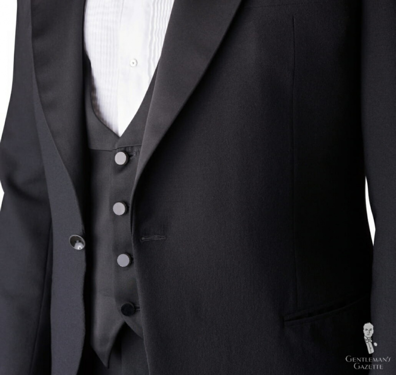 Un gilet à cravate noire correct est juste assez grand pour être vu par-dessus une veste boutonnée (bien que la veste soit souvent laissée déboutonnée lorsqu