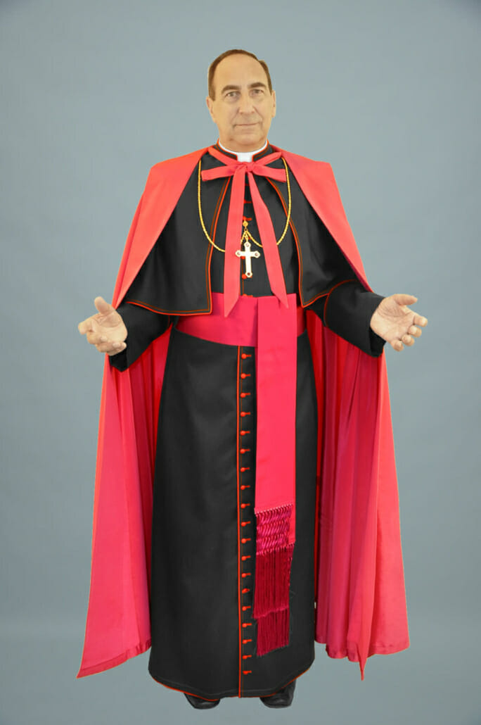 Katolický biskup v tradičním ferraiolone a sutaně s šerpou známou jako band cincture nebo fascia