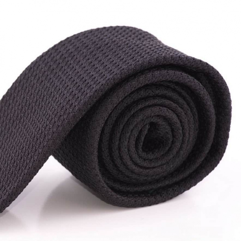 Une cravate grenadine noire retroussée