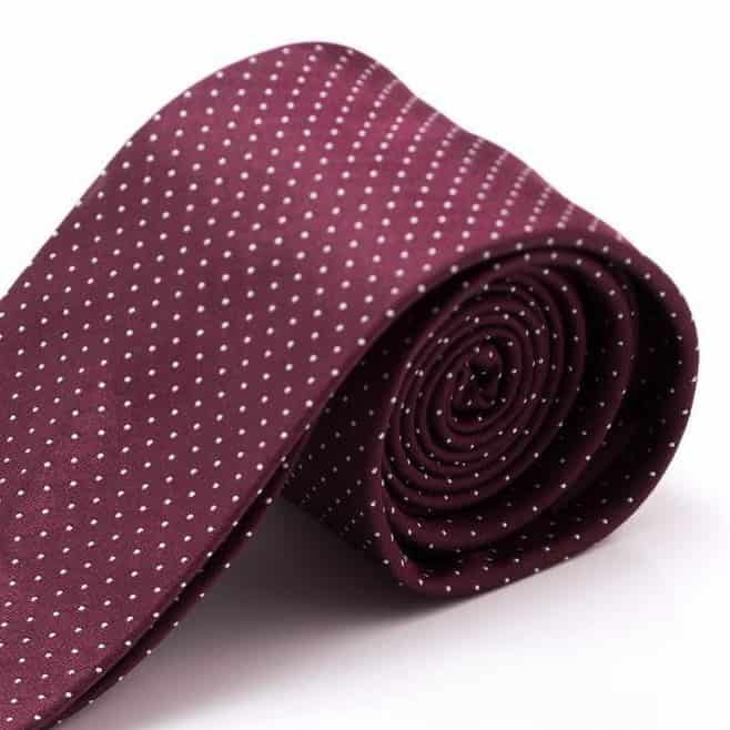 Een foto van een bordeauxrode stropdas met witte stippen