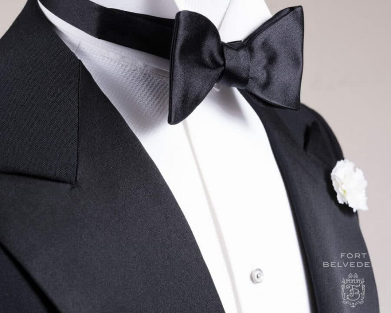 Černá motýlková kravata s jedním koncem z hedvábného saténového motýlka s bílou karafiátovou hedvábnou boutonniérou