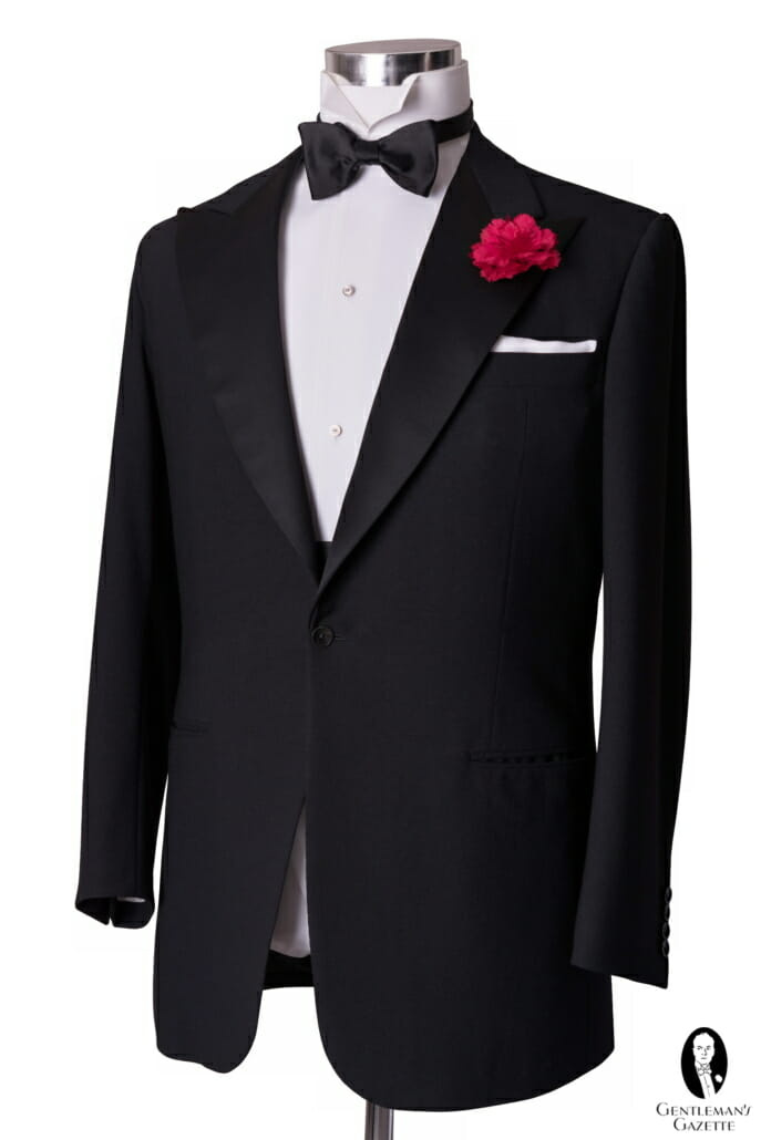 Le modèle le plus traditionnel de veste de smoking : noir et simple boutonnage avec un bouton de fermeture, revers en pointe avec parements en soie, et pas de fentes arrière.