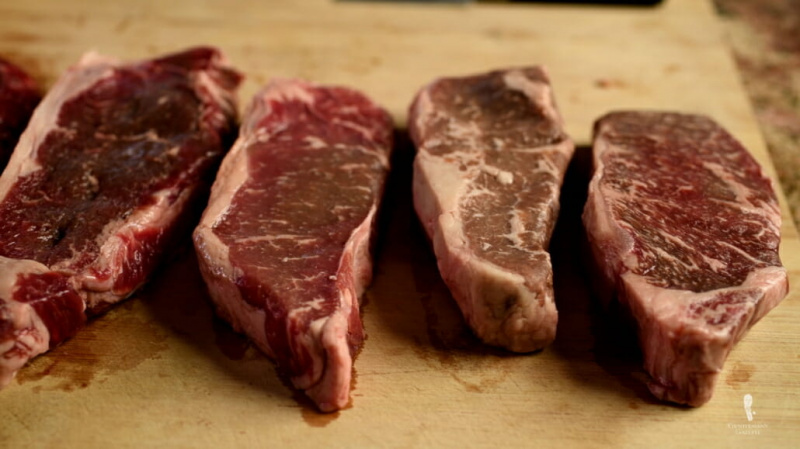 New York Strip alias Kansas City Strip Steak coupe avec différents degrés de persillage - De droite à gauche - Akaushi, Prime, Select, Grass Fed