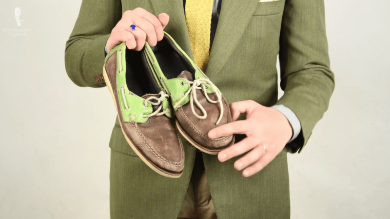 Ношене тамноплаве и светлозелене ципеле чамце са белим кожним везицама