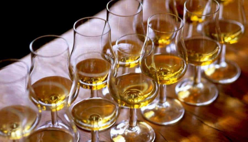 Degustación de whisky seis vasos en mesa de madera.