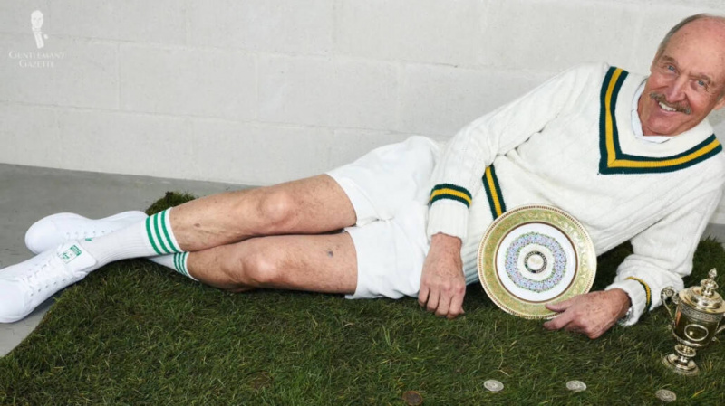 Stan Smith na sobě pár bílých tenisek Adidas.