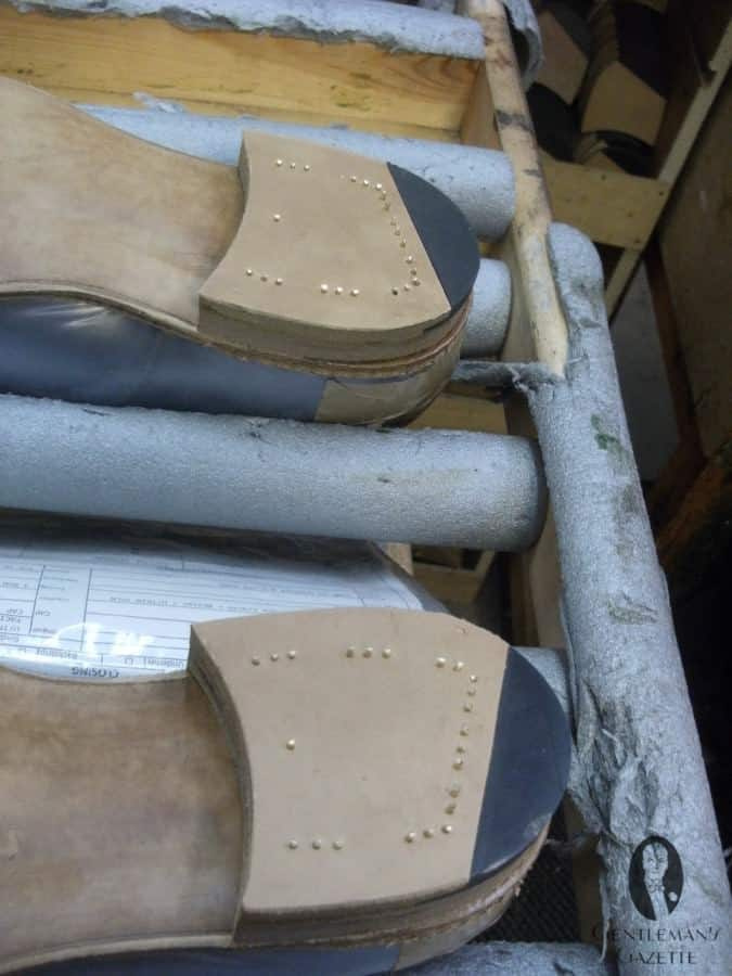 Os sapatos EG têm saltos distintamente pregados. Estes aguardam acabamento.