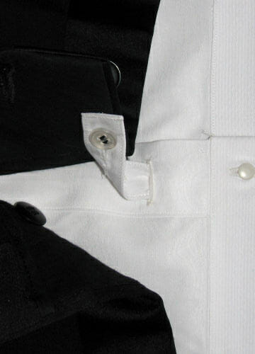 Une patte sous les boutons de la bavette à la taille du pantalon pour empêcher la chemise de remonter.