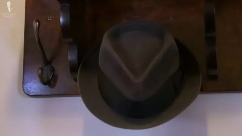 Brown Fedora guardado em um gancho de chapéu.